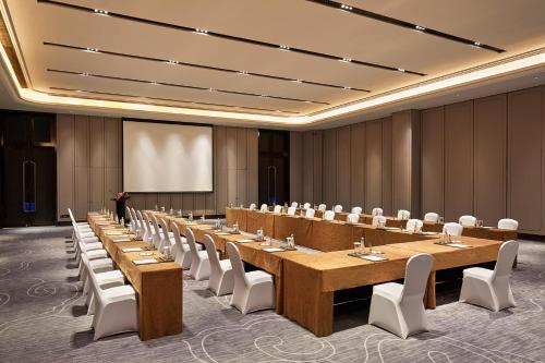 a large meeting room with a long table and chairs at Wanda Vista Harbin in Harbin