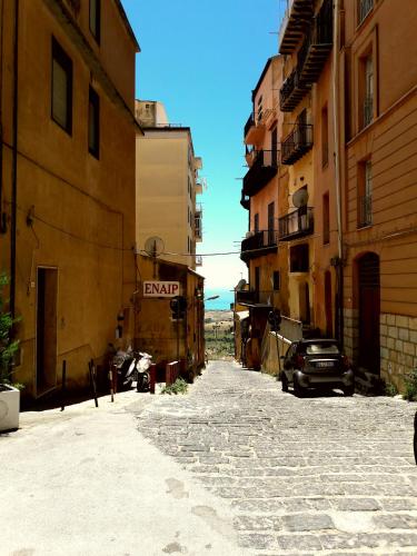 an alley in a city with buildings and a car at Dimora Hostel in Agrigento