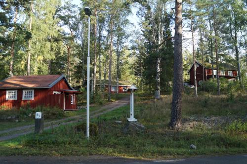 a group of cabins in a forest with a street light at Gutzeit in Ädelfors
