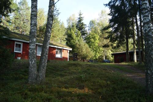 a red house in the middle of a forest at Gutzeit in Ädelfors