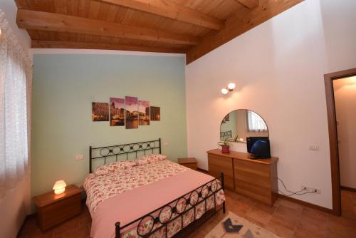 a bedroom with a bed and a dresser and a mirror at Appartamento Ca' Tiziana - Venice - Jesolo in Musile di Piave