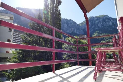 a balcony with a chair and a view of mountains at Pensiunea Pinul Negru in Băile Herculane