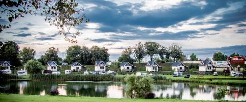 a row of houses next to a lake at Magnolia Pokoje Gościnne in Malbork