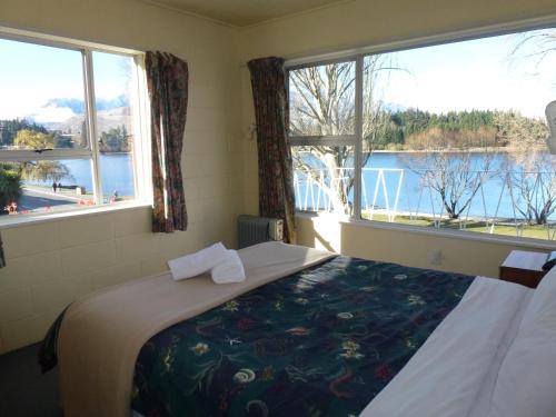 a bedroom with a bed with a view of the water at Lakeside Motel in Queenstown