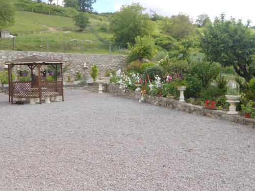 a garden with a gazebo and a bunch of flowers at Gîte La Lieutenance in Saint-Pourçain-sur-Sioule