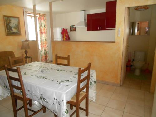 a dining room with a table and chairs and a kitchen at Gîte La Lieutenance in Saint-Pourçain-sur-Sioule