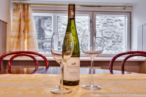een fles wijn zittend op een tafel met twee glazen bij Daily Apartments - Old Town in Tallinn