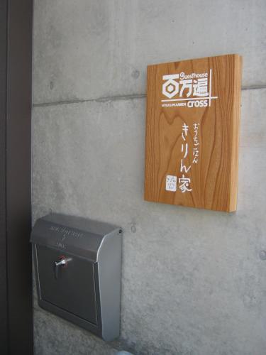a sign on a wall next to a box at Guesthouse Hyakumanben Cross in Kyoto