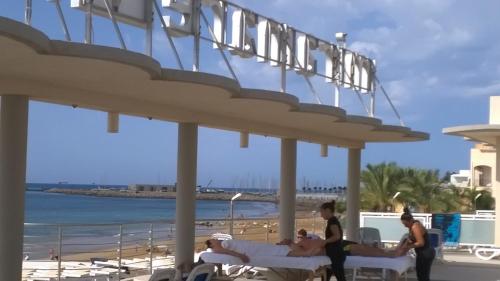 a group of people laying on beds on the beach at Hotel Miramare in Marina di Ragusa