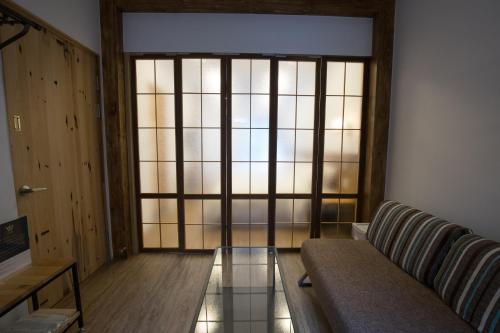a living room with a couch and a large window at Atreeium in Tainan