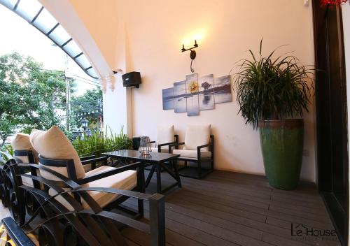 a patio with a table and chairs and a table and a plant at Le House Boutique Hotel - 100m to the beach in Da Nang