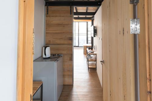 a hallway leading to a kitchen with wood walls at Atreeium in Tainan