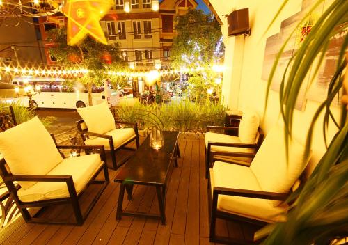 a patio with chairs and a table and lights at Le House Boutique Hotel - 100m to the beach in Da Nang