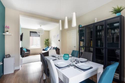 a dining room and living room with a white table and chairs at Bishop's Rest in Bishop Auckland