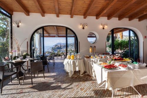 a restaurant with tables with food on them at Hotel Villa Enrica - Aeolian Charme in Lipari