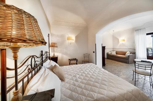 a bedroom with a bed and a living room at Hotel Villa Enrica - Aeolian Charme in Lipari