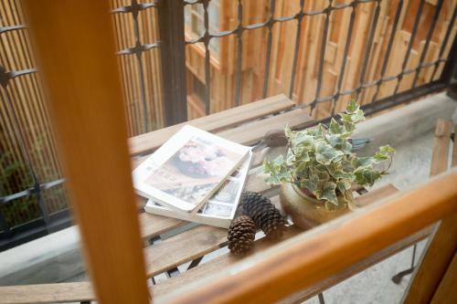 a table with a book and a plant on a balcony at Atreeium in Tainan