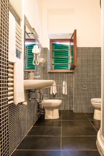 a bathroom with a sink and a toilet and a window at B&B Villa Regina in Pisa