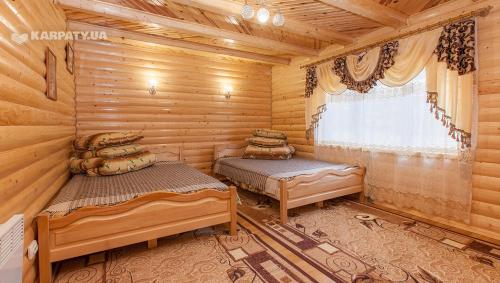 um quarto com 2 camas num chalé de madeira em Karpatskyi Diamant em Yaremche