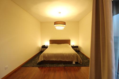 a bedroom with a bed and two side tables at Agudela Vista Mar in Lavra