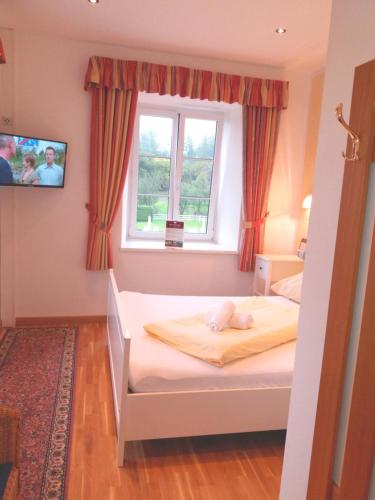 a small bedroom with a bed with a window at Gut Drasing in Krumpendorf am Wörthersee