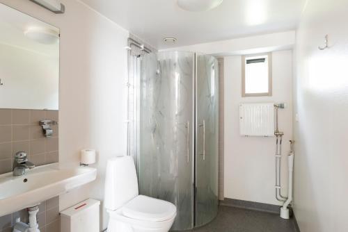 La salle de bains blanche est pourvue d'une douche et de toilettes. dans l'établissement First Camp Västerås-Mälaren, à Västerås