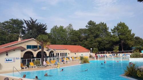 une grande piscine avec des gens dans l'eau dans l'établissement Mobile Home bois dormant, à Saint-Jean-de-Monts