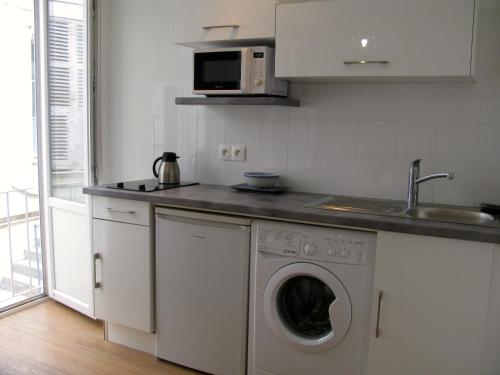 una cucina con lavatrice e lavandino di Place Wilson a Nizza
