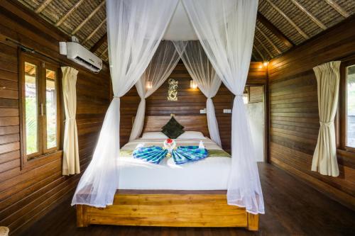 a bedroom with a bed in a wooden room at Laguna Reef Huts in Nusa Lembongan