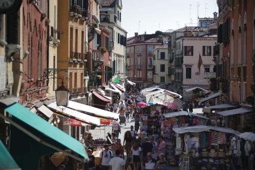 a crowd of people walking down a street with vendors at Ca' Pozzo Inn in Venice