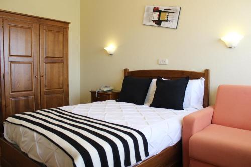 a hotel room with a bed and a chair at A Muralha in Almeida