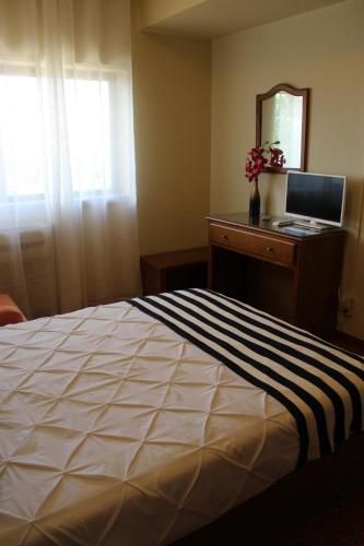 a bedroom with a bed and a desk with a computer at A Muralha in Almeida