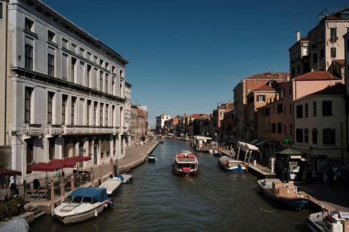 a canal with boats in a city with buildings at Ca' Pozzo Inn in Venice