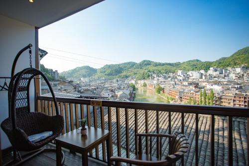 a balcony with a table and chairs and a view of a city at Wang Jiang Reclusive Boutique Inn in Fenghuang