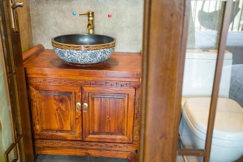 a bathroom with a bowl sink on a wooden cabinet at Wang Jiang Reclusive Boutique Inn in Fenghuang