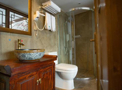 a bathroom with a sink and a toilet and a shower at Wang Jiang Reclusive Boutique Inn in Fenghuang