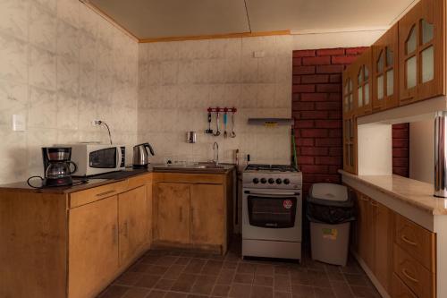 a kitchen with a stove and a sink at Cabañas Última Esperanza in Puerto Natales