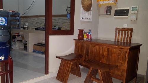 a kitchen with a counter and two wooden stools at Umayuri Inn in Ubud