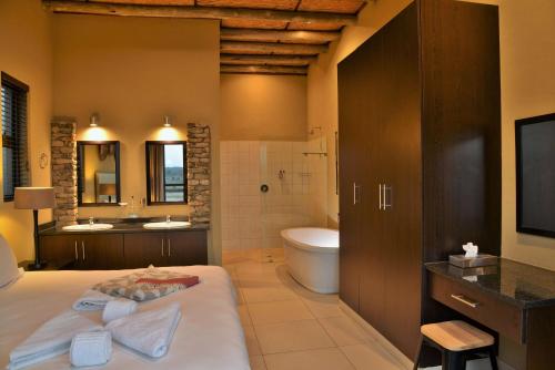 y baño con cama, aseo y lavamanos. en Mjejane Bush Camp by Dream Resorts, en Hectorspruit