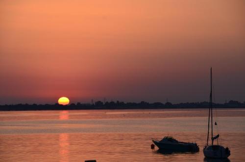 two boats sitting in the water at sunset at Hotel et Spa Les Cleunes Oléron in Saint-Trojan-les-Bains