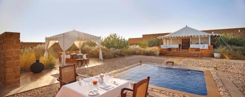 a backyard with a swimming pool and a gazebo at SUJÁN The Serai Jaisalmer in Jaisalmer