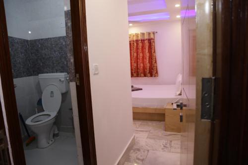 a bathroom with a toilet and a bath tub at Backpackers Heaven New King - New Delhi Train Station in New Delhi