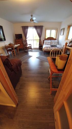 a living room with a couch and a bed at Hebergement Cerfs-Tifie fermette in Saint-Félix-d'Otis