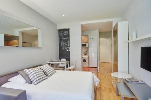 sypialnia z białym łóżkiem i kuchnią w obiekcie LEEWAYS LOFT in FUENCARRAL w Madrycie