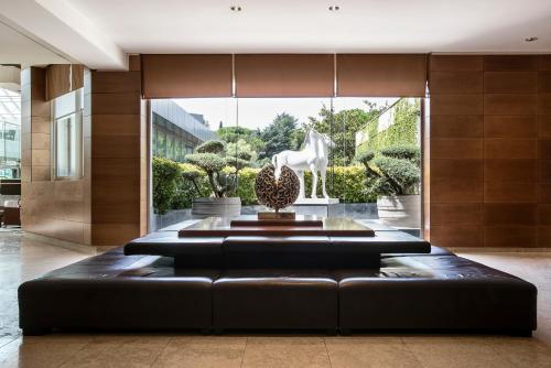 a lobby with a black couch and a white horse statue at Ergife Palace Hotel in Rome