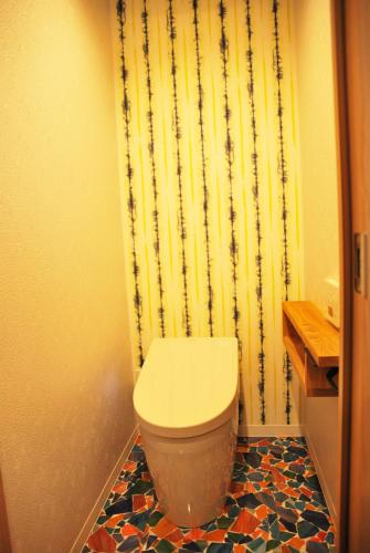 a bathroom with a toilet and a shower curtain at Kurashiki Base Inarimachi in Kurashiki