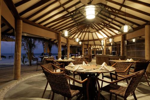 a restaurant with tables and chairs with a view of the beach at Drift Thelu Veliga Retreat in Dhangethi