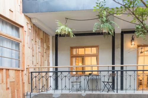 a balcony with chairs and a table on a building at Atreeium in Tainan