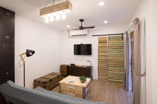 a living room with a couch and a tv at Atreeium in Tainan
