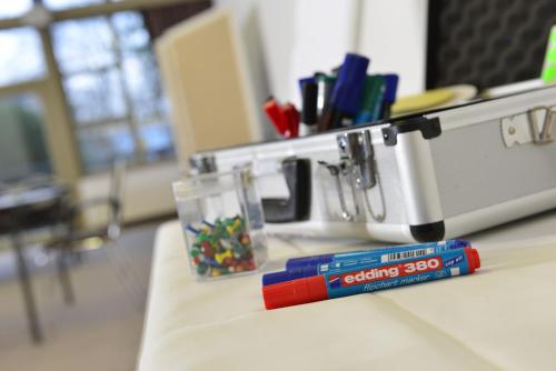 a desk with a pile of markers and a glass at Landhotel Schnuck in Schneverdingen